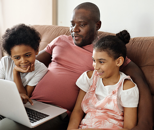 padre e hijos mirando un ordenador