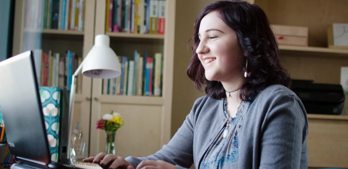 chica mirando el ordenador y sonriendo