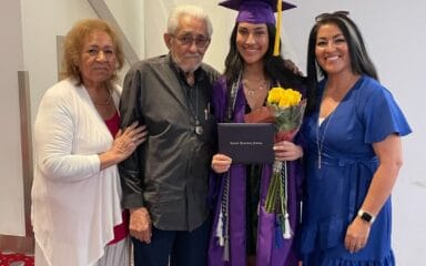 Un estudiante que se graduó haciéndose una foto con su familia