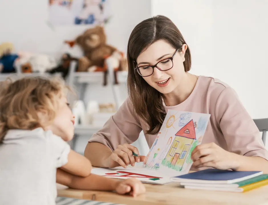 Estudiante de educación infantil con una niña hablando de un dibujo