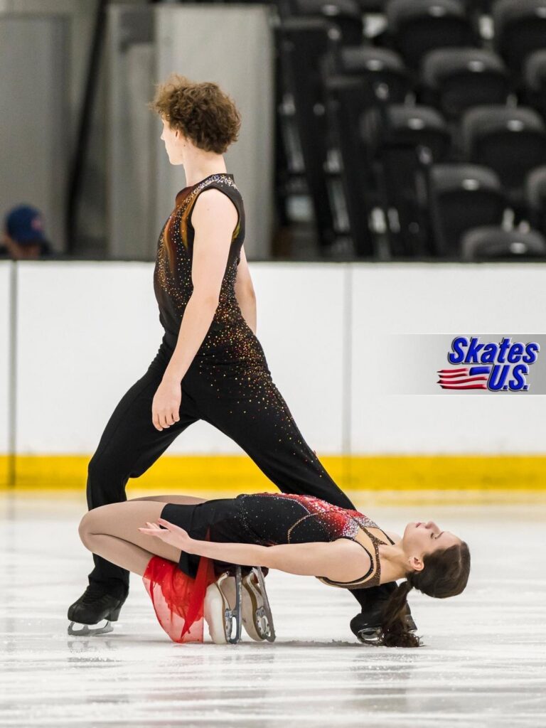 Jane Calhoun y su pareja adoptan una pose expresiva durante una competición de patinaje artístico.